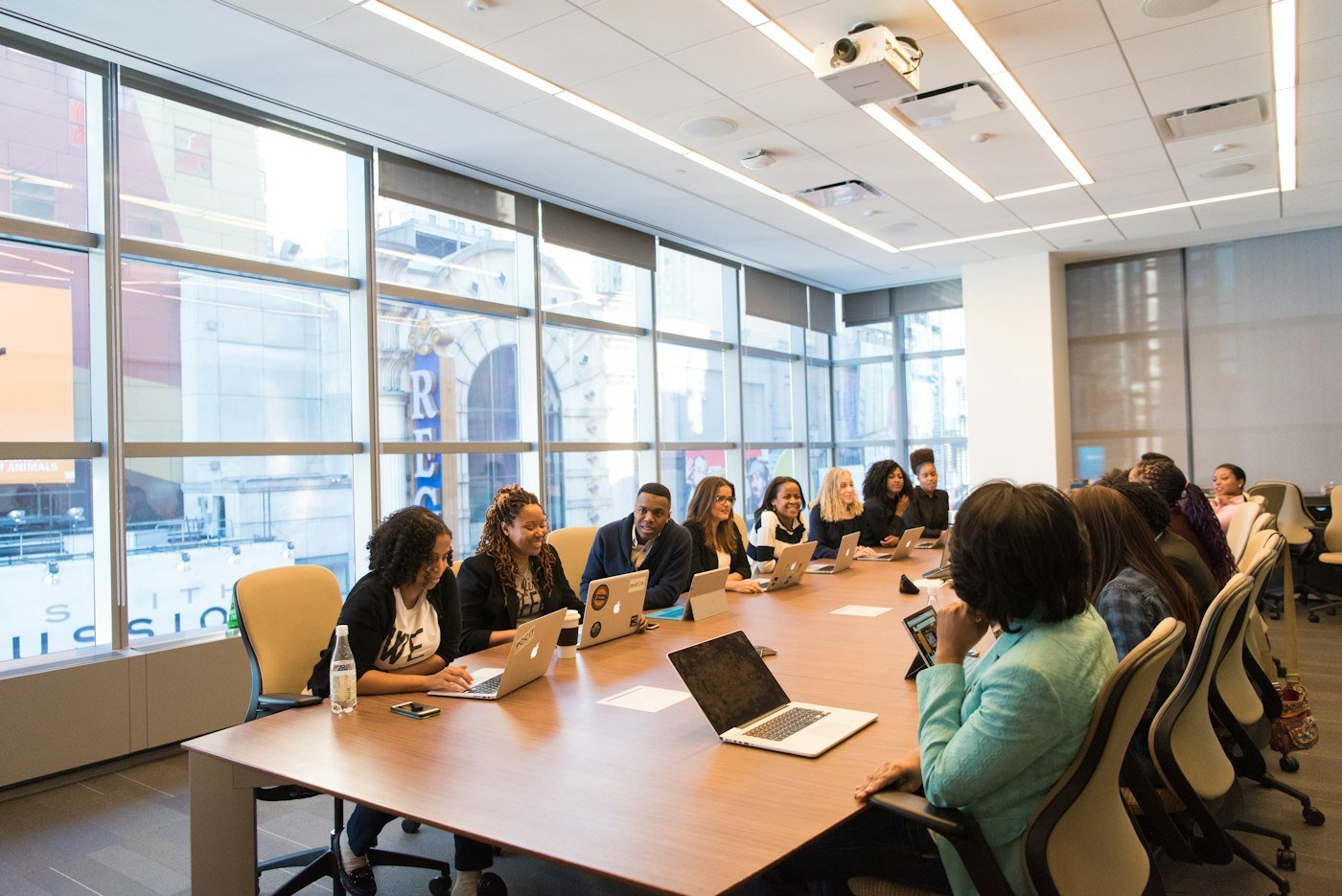 Team meeting around a boardroom table with laptops